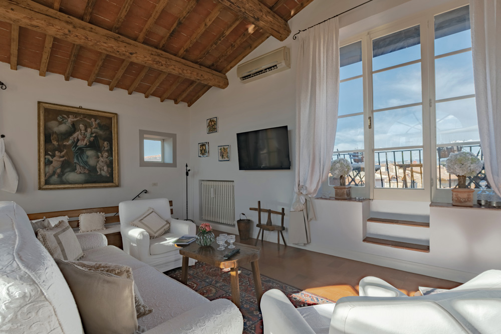 Large living room with exposed beams and bright windows