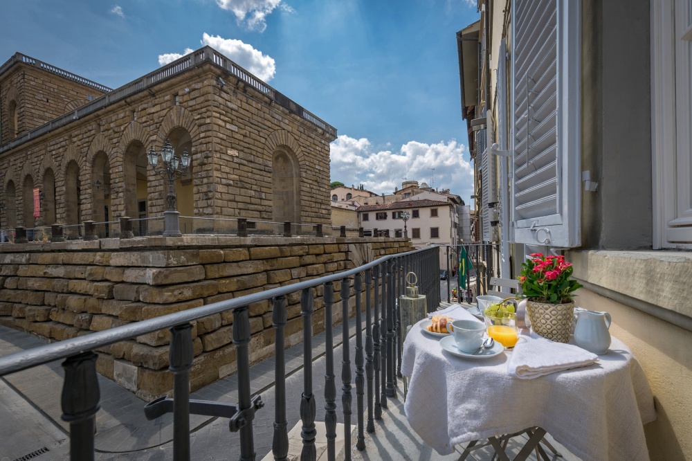 Breakfast setup on balcony with view of Pitti Palace in Florence