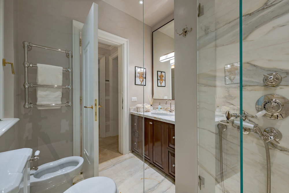 Bathroom with glass shower and marble finishes in Unicko apartment in Florence