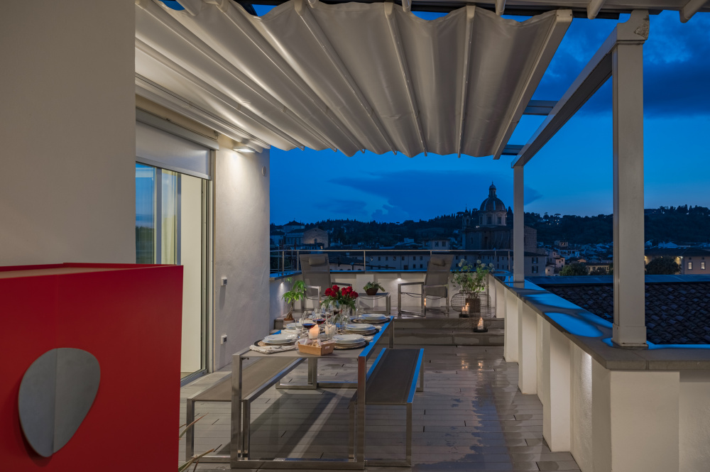 Covered terrace with seating area and night ambiance