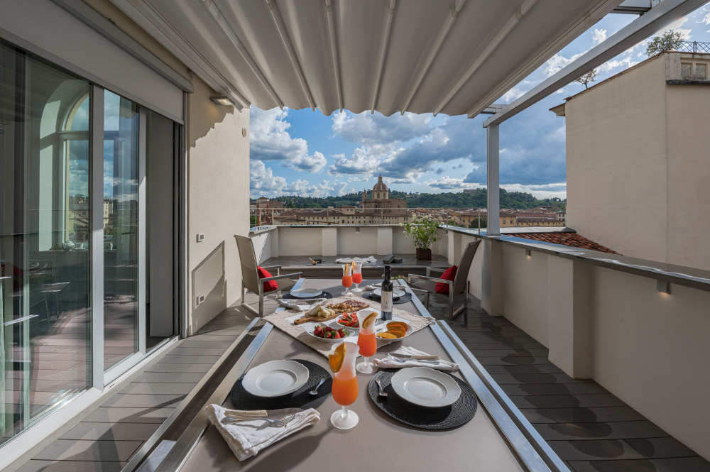 Outdoor table setup on terrace with skyline view