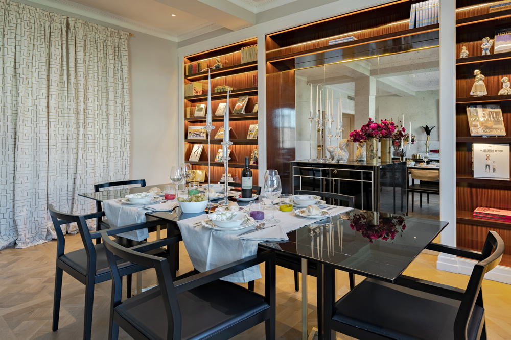 Dining room with library wall in Unicko luxury apartment in Florence