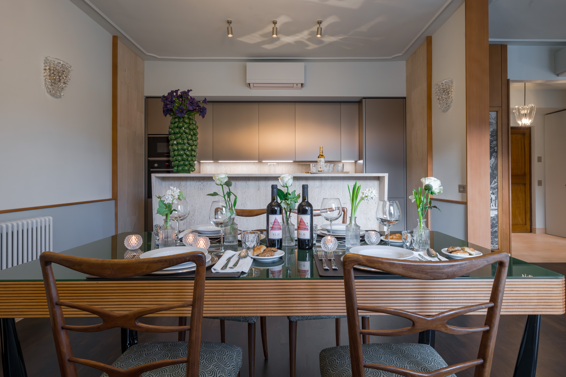 Dining table set in front of modern kitchen in Ponte Vecchio Panorama apartment Florence