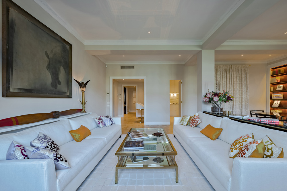 Elegant lounge area in Unicko luxury apartment in Florence with white sofas and glass table