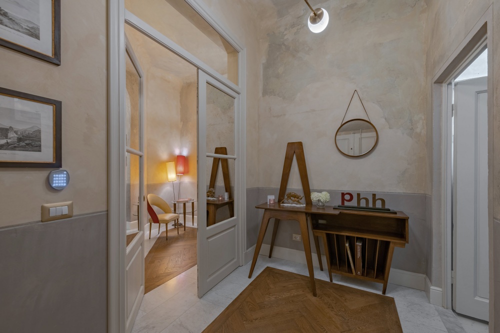 Stylish entrance hallway with wooden floors and interior view in historic Florence apartment