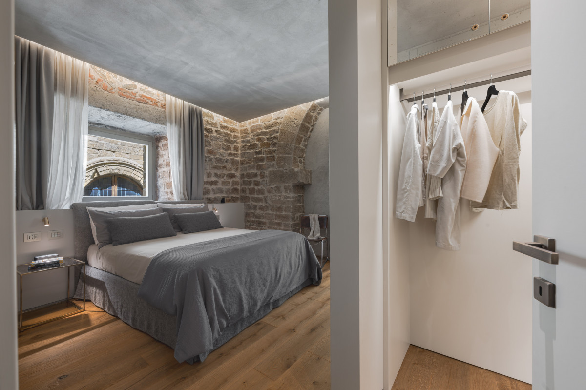 Luxury bedroom in historic apartment in Florence with parquet floor and classic Italian design