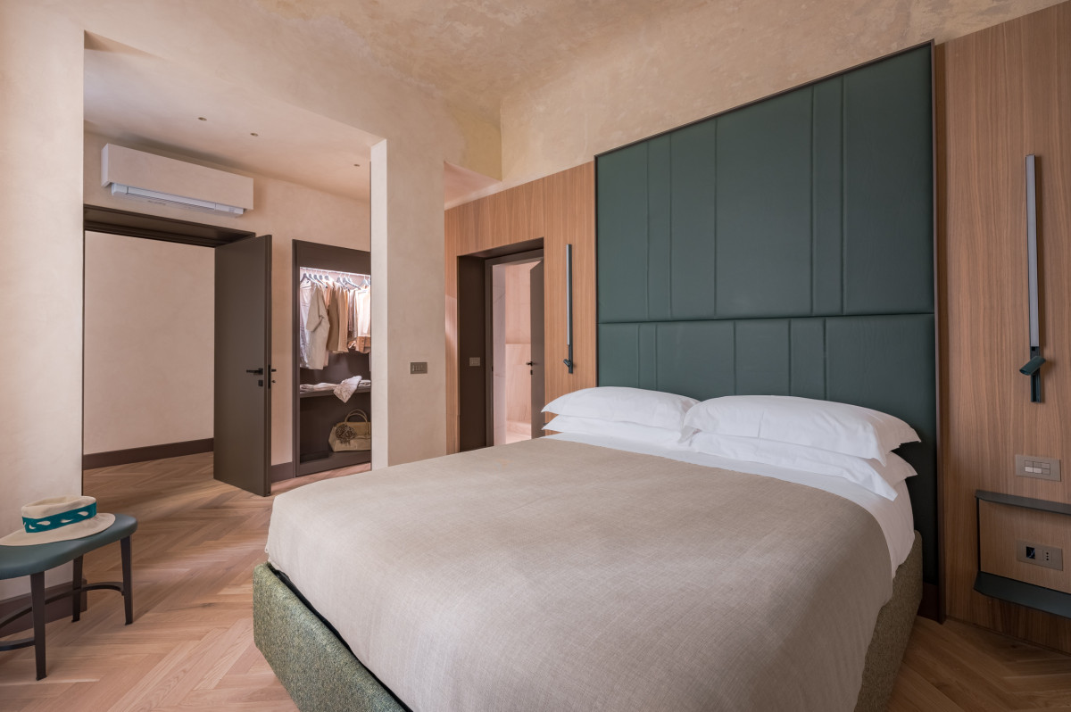 Bedroom with green headboard in Florence apartment