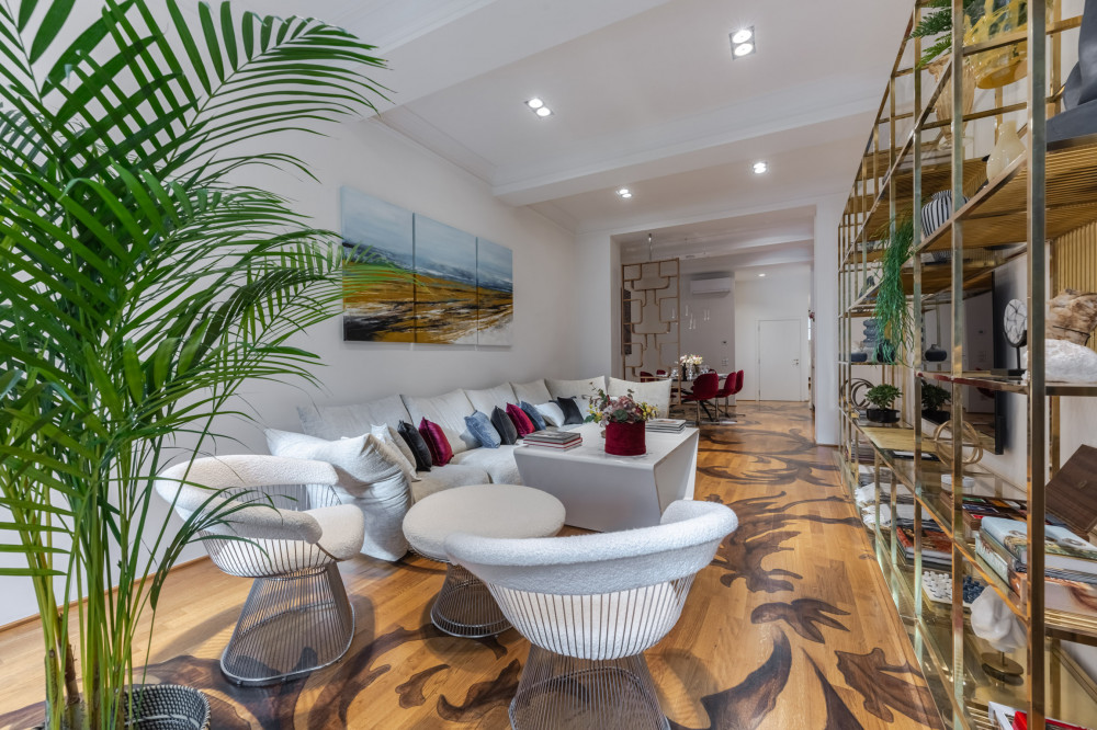 Bright living room in Florence apartment with white armchairs