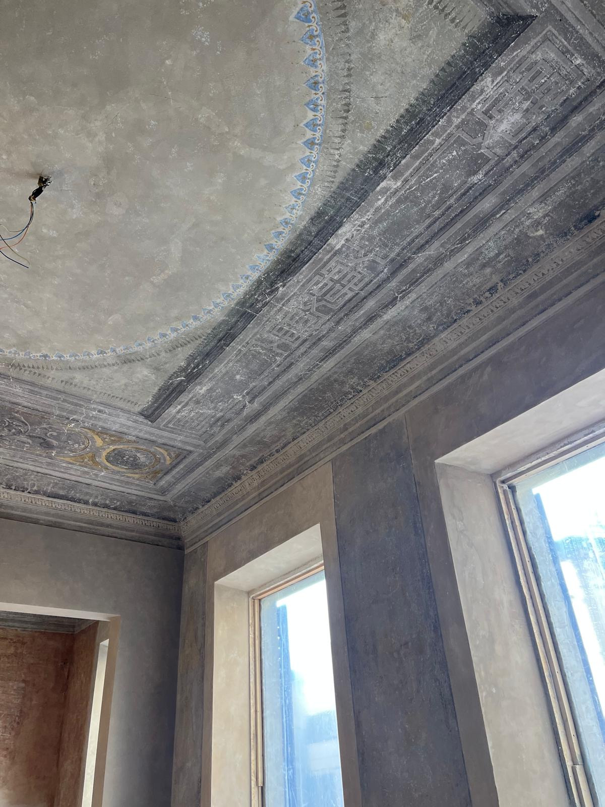 Detailed fresco ceiling during restoration in Florence historic apartment