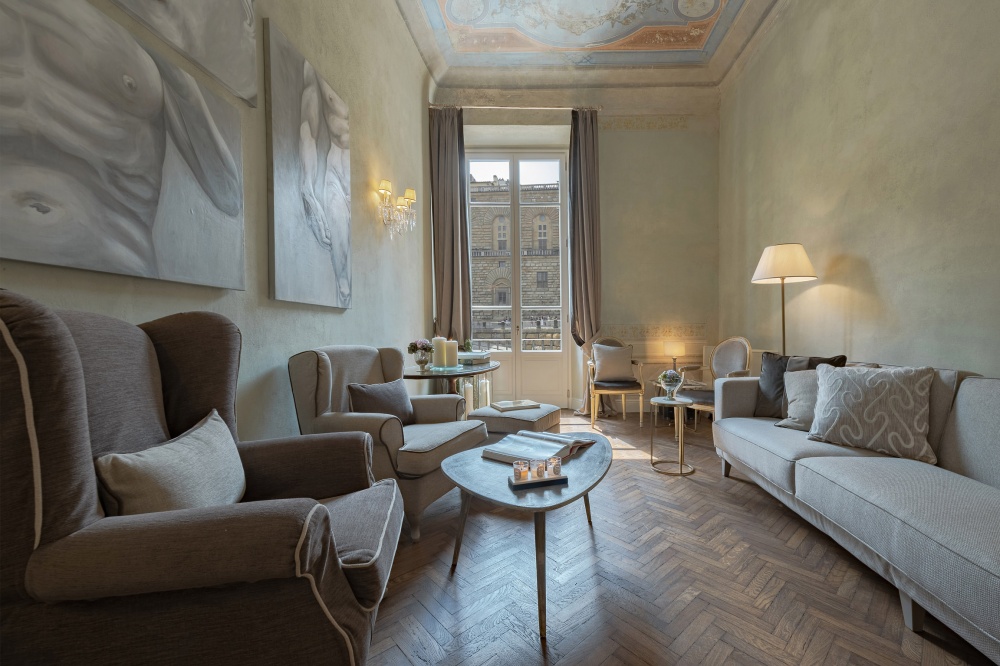 Elegant living room with sofa and armchairs in historic Florence apartment