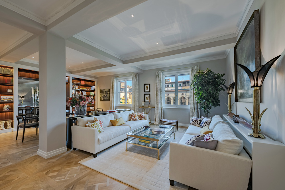Spacious living room in Unicko luxury apartment in Florence with elegant sofas and parquet floor