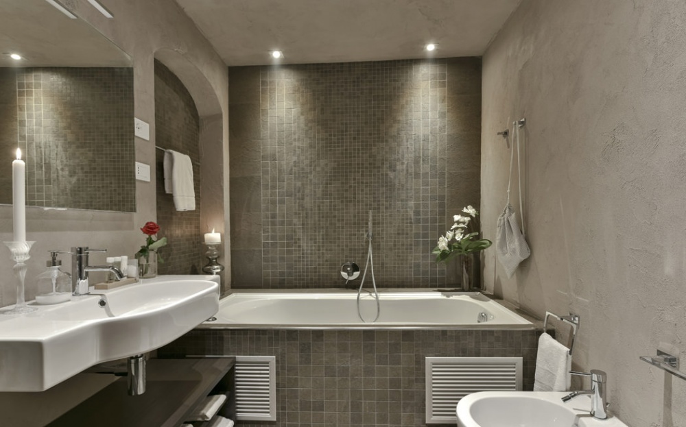 Luxury bathroom with bathtub, stone tiles and modern design in historic apartment near Piazza Pitti Florence