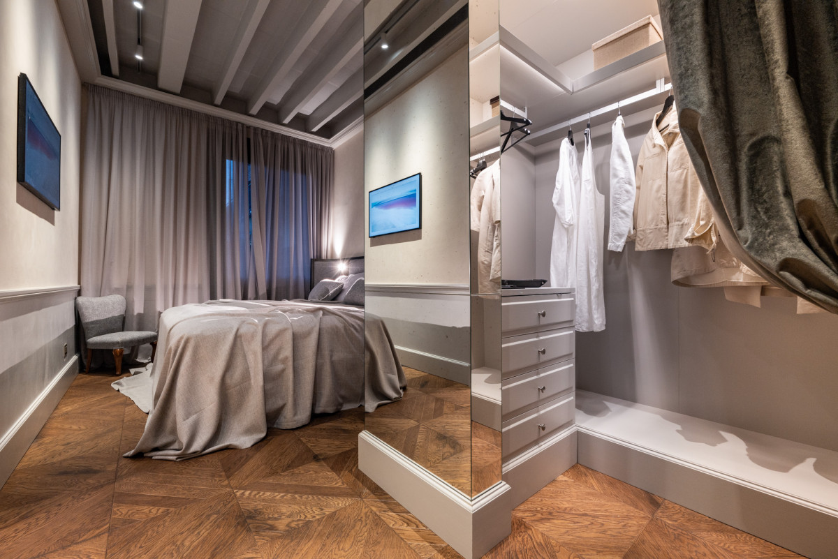 Elegant bedroom in luxury Florence apartment with parquet floor and soft lighting