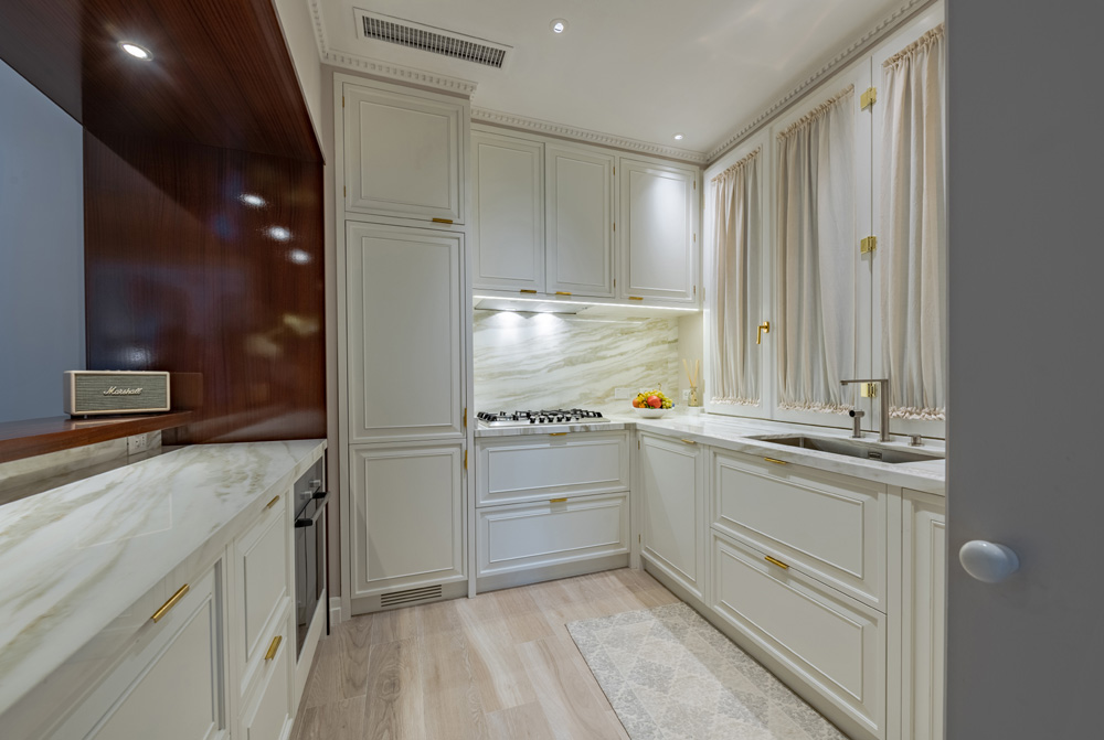 Luxury kitchen in Unicko apartment in Florence with white cabinetry and marble details