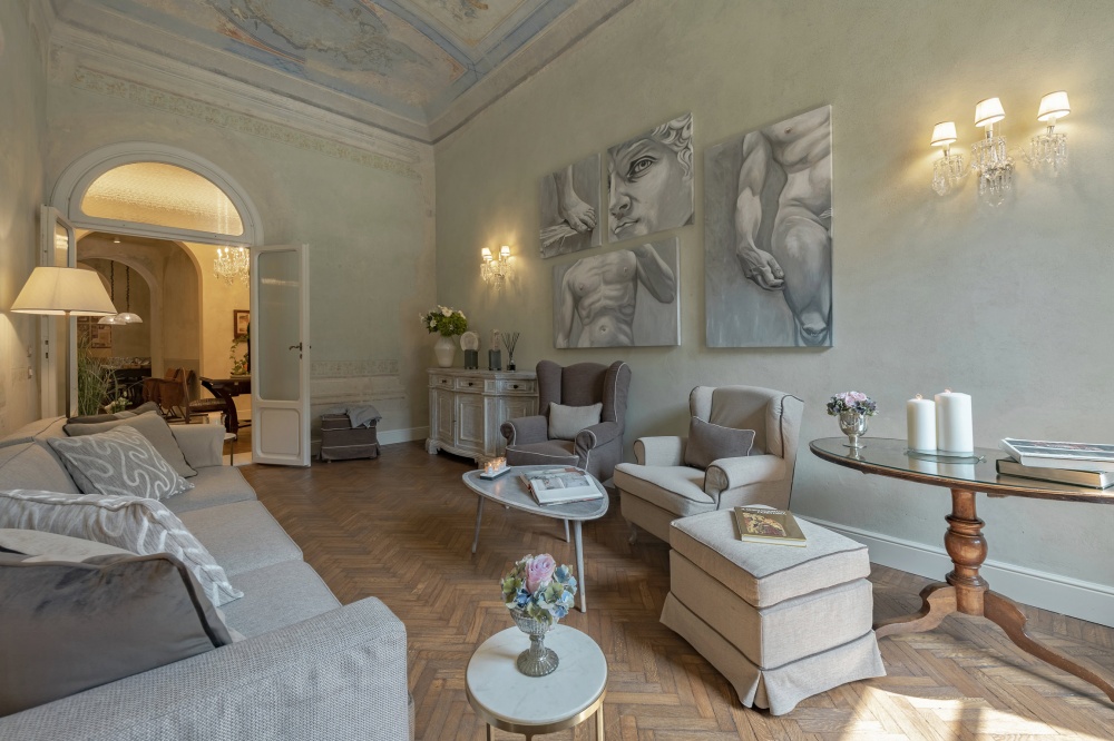 Elegant living room with frescoed ceiling in Pitti Historical Home luxury apartment in Florence