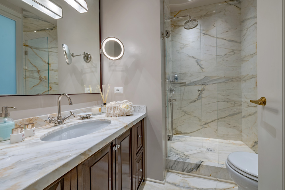 Marble bathroom with shower and vanity in Unicko apartment in Florence