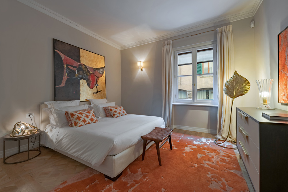 Master bedroom with orange details in Unicko luxury apartment in Florence