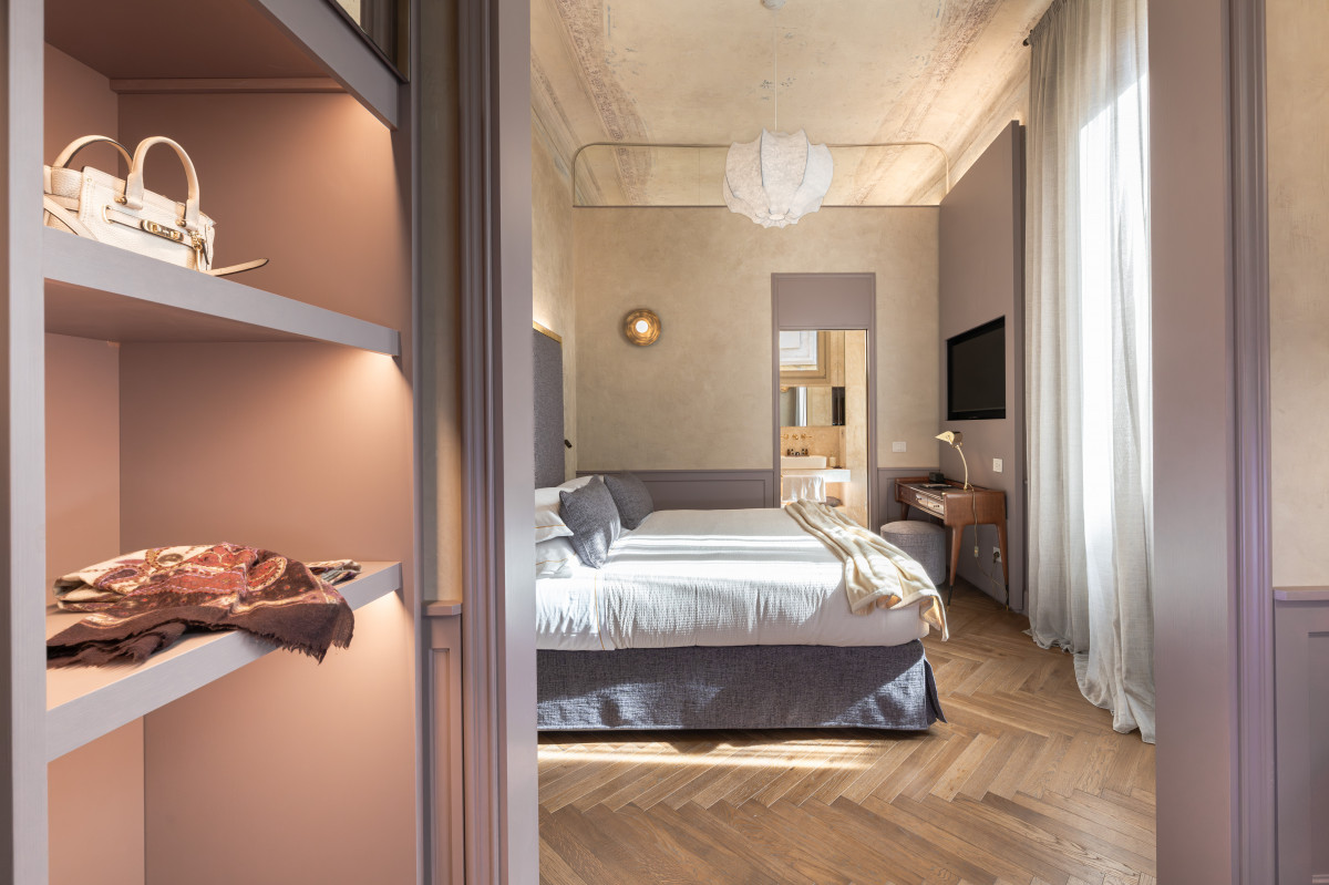 Luxury bedroom in historic apartment in Florence with parquet floor and classic Italian design