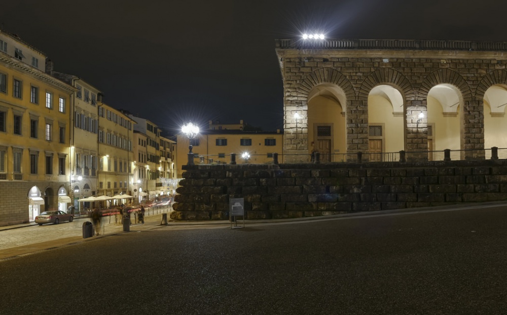 Night view of illuminated arches and historic architecture in Piazza Pitti Florence near luxury apartment