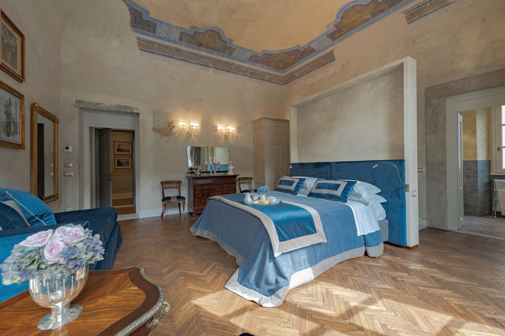 The luxurious bedroom of the Pitti Historical Home apartment elegantly furnished in azurite blue